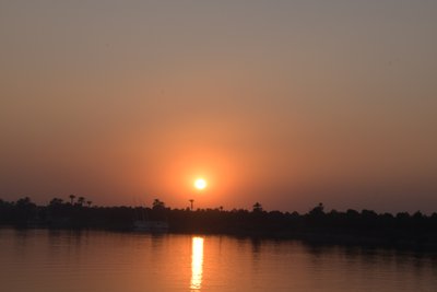 Golden Sunset Reflections on a Tranquil River by Albert Mansour