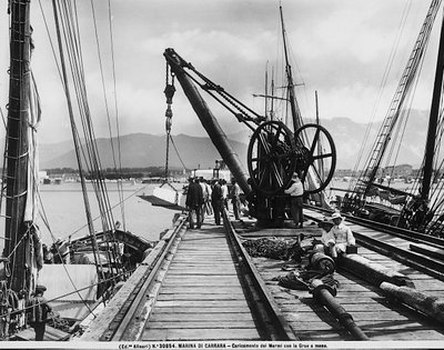 Loading blocks of marble with a hand crane in Marina di Carrara by Fratelli Alinari