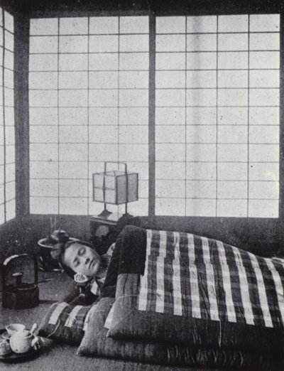 Girl asleep between wadded quilts with a wooden pillow by American Photographer (after)