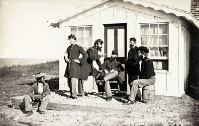 Five Civil War soldiers gathered on dirt porch outside home, African American youth seated near them by American Photographer
