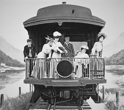 Tourists taking scenic photographs from the rear observation platform of a Union Pacific train by American Photographer
