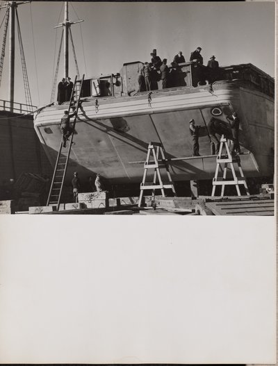 A group of men work on a docked boat by Arnold Eagle