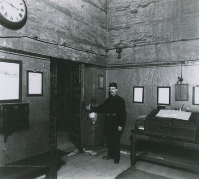 A Prison Warder Stands by a Door in the Entrance Hall by English Photographer