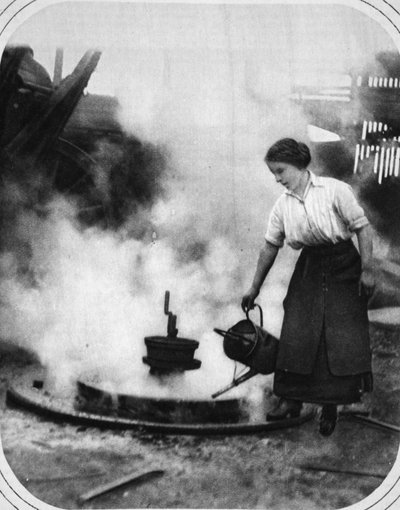 A ready helper in war time: Miss Edith Hawley cooling-off a wheel by English Photographer