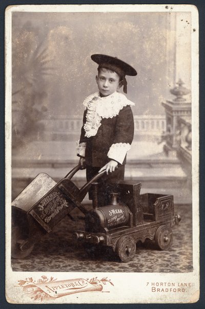 Boy with a toy train and wheelbarrow by English Photographer