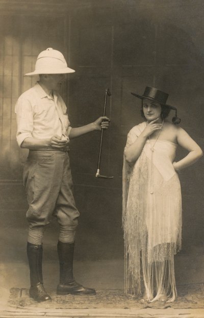 Portrait of a man dressed for riding and a woman wearing a hat and a dress by English Photographer