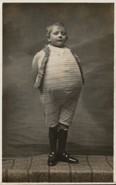 School Boy, Dressed Up to Have a Very Large Stomach by English Photographer