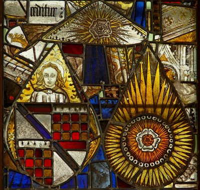 A panel in the east window depicting an angel with a shield of arms and 2 roses within sunbursts by English School