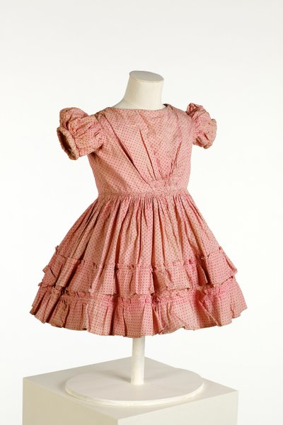 Childs dress with puff sleeves and frilled skirt, printed with pink spot pattern, c.1850 by English School