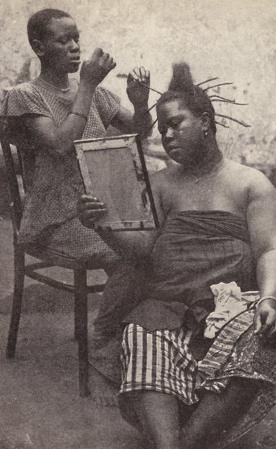 West African Woman Having Her Hair Done (b/w photo) by European Photographer