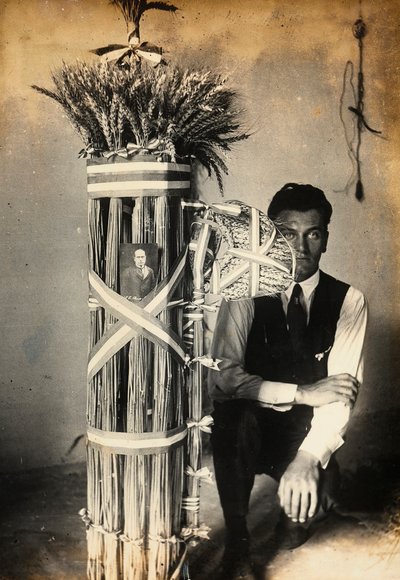Antonio Floridi posing near fasces of lictors made of ears of wheat. Farm owned by Camillo Frizzoni, in Morengo, province of Bergamo. On top of the fasces is a photo of Mussolini by F. Frizzoni