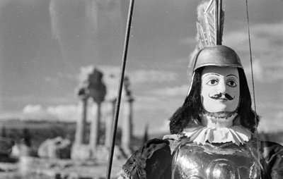Sicilian Puppet. In the Background the Temple of Castor and Pollux in the Valley of the Temples in Agrigento by Fosco Maraini