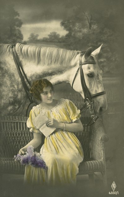 Girl sitting on sofa with white horse behind by French Photographer