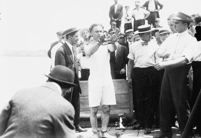 Harry Houdini being handcuffed before being nailed into a crate and lowered into New York Bay, 1912 by George Grantham Bain