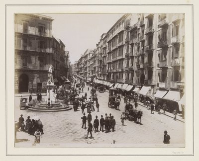 View of Via Roma in Naples with a Statue, Shops, Horse Carriages, and Passersby by Giorgio Sommer