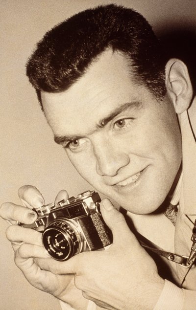 Milwaukee Post photographer James L. Stanfield holding a camera by James L Stanfield