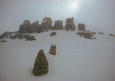 Statue of a god peers above a blanket of snow at Nemrud Dagh. Nemrud Dagh, Turkey. by James L Stanfield