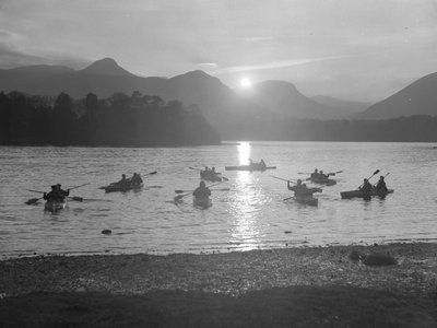 A view of people canoeing on Derwentwater at either sunrise or sunset by Joseph Hardman