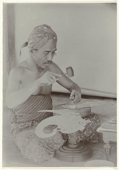 Javanese Man Creating a Human-Like Figure with Hammer and Instruments by Kassian Cephas