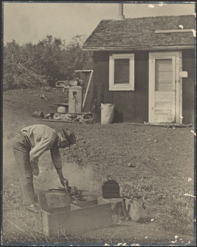 Man Bent Over Smokey Fire Outside by Louis Fleckenstein
