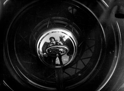 People Reflecting in a Ford Hubcap by Luigi Leoni