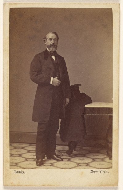 [Unidentified Bearded Man Standing, a Top Hat and Coat on Nearby Table] by Mathew B. Brady