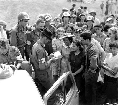 An American soldier attempts to communicate with local people, Orleans by Photographer French