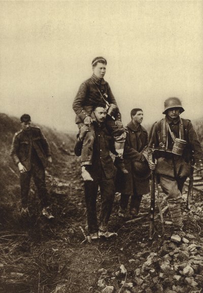 German infantryman with a leg wound being carried from the battlefield by British prisoners, World War I by Photographer German