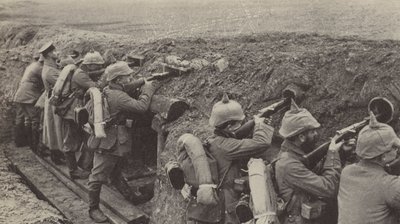German soldiers in the trenches in Flanders firing through loopholes made from small wooden boxes and sewer pipes by Photographer German