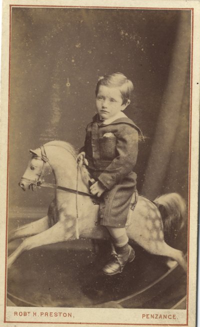 Young boy sitting on a rocking horse by Robert H. Preston