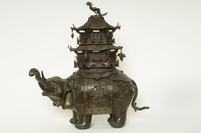Figure of an elephant wearing a howdah cloth, elaborate surcingle and a pagoda building by Japanese School