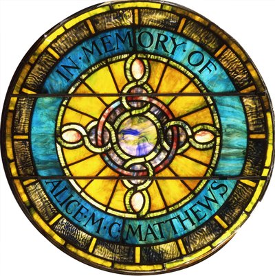 A circular leaded glass window by Tiffany Studios by Studios Tiffany