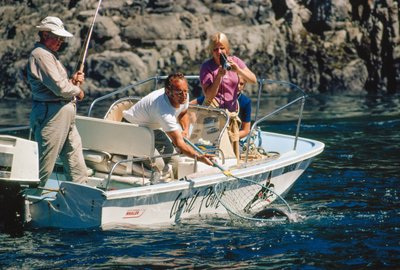 An angler reels in a salmon at Bute Inlet by Ted Spiegel