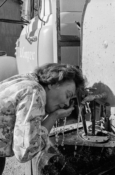 Mildred Cooper, a truck driver, washes her face from road dust by Ted Spiegel