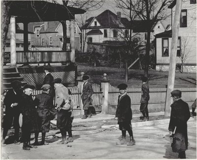 A Group of Boys in Winter Coats Standing on an Unidentified Street Either Before or After a School Day. by Unbekannt