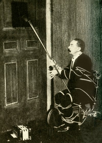 John Nevil Maskelyne performs a spirit cabinet illusion, c1910 by Unbekannt