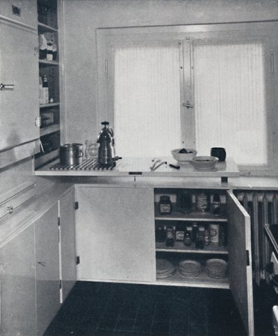 Kitchen with a black Dutch tiled floor, white walls and built-in shelves and cupboards by Unbekannt