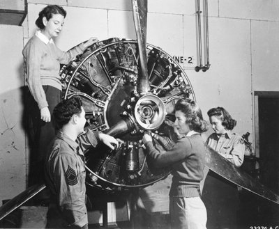 Wasps learn where the power comes from in the B-17 Flying Fortress engine while attending B-17 pilot training at Lockbourne AAB, Working on the propeller mechanism, while a crew chief looks on, they are Patricia Bowser, Ann Waldner and Frances Green by Benjamin Baud