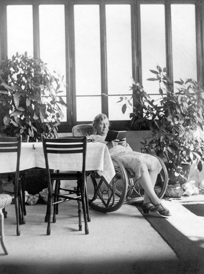 Woman sitting in a rocking chair, reading a book. 1915 approx. Germany by Unbekannter Künstler