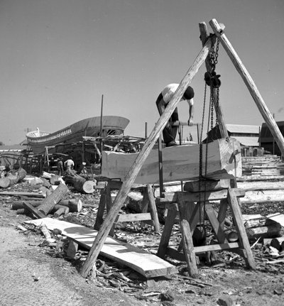 Portuguese boatbuilders artisans build a fishing boat from wood and using a crosscut saw by Volkmar Wentzel
