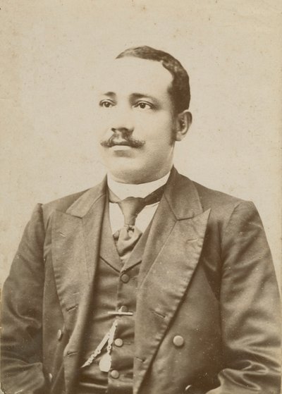 Photograph of a man wearing a dark colored suit with a pocket watch in his vest by W. M. Hubbard