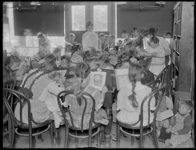 Children reading in the reading room of an unidentified branch of the Queens Borough Public Library, c.1910 by William Davis Hassler