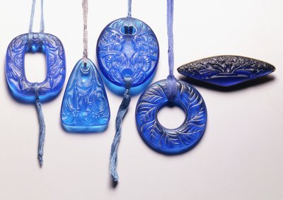 Four turquoise glass pendants and a gilt metal mounted glass brooch