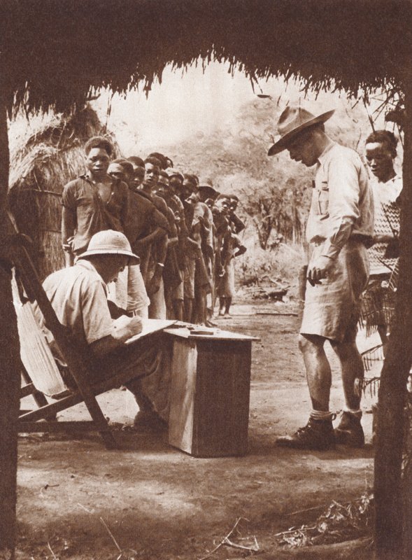 Native workers, queuing to be paid in the African bush by English Photographer