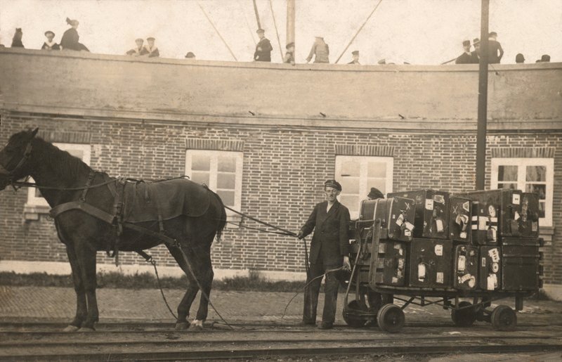 Porter with a horse-drawn luggage trolley at the docks by European Photographer
