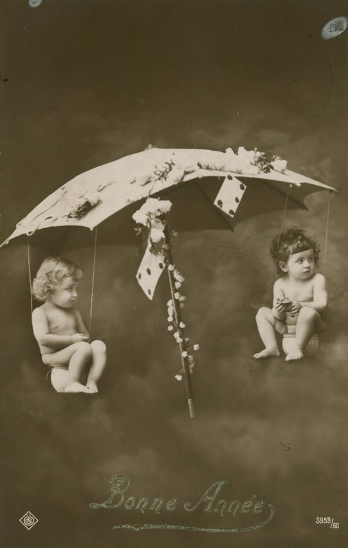 Happy New Year card with two babies hanging from an umbrella by French Photographer
