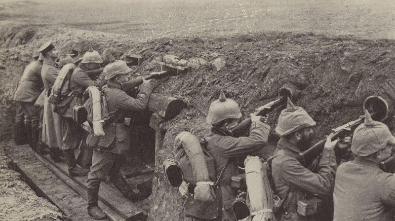 German soldiers in the trenches in Flanders firing through loopholes made from small wooden boxes and sewer pipes by Photographer German