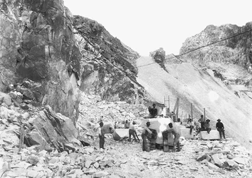 Excavators at work at a marble quarry in the Apuan Alps, Tuscany. Some of them are seated on blocks of marble already squared off.