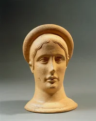 Close-up of a bronze votive feminine head with a cap, Italic civilization, 4th-3rd century BC