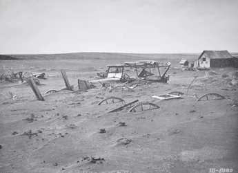 Car and farm machinery buried by dust and sand, Dallas, South Dakota